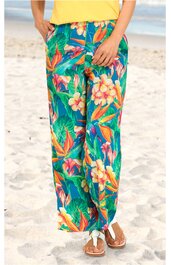 Weite lange Hose in Türkis mit buntem tropischem Blumen- und Blattmuster, elastischer Bund, seitliche Eingrifftaschen, getragen von stehender Person