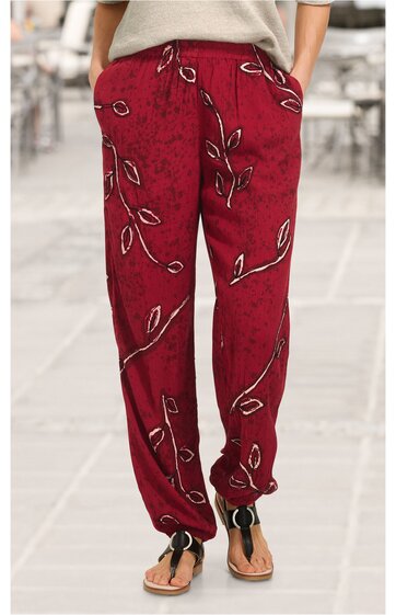 rote lange Hose mit schwarzem und weißem Blattmuster, geradem Schnitt, elastischer Bund mit Kordel, Eingrifftaschen, getragen von stehendem Modell