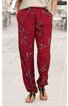 rote lange Hose mit schwarzem und weißem Blattmuster, geradem Schnitt, elastischer Bund mit Kordel, Eingrifftaschen, getragen von stehendem Modell