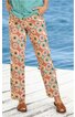 Hose mit weitem Bein, hellbeige Grundfarbe, buntes geometrisches Muster mit orange, blau und grün, gerade geschnitten, getragen von stehender Person, kombiniert mit türkisfarbenem Oberteil und braunen Sandalen