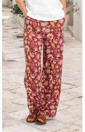 Weite lange Hose in rot mit gelbem und grünem Blumenmuster, gerader Schnitt, getragen von stehender Person, elastischer Bund, Taschen an den Seiten