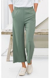 Hose in salbeigrün, weit geschnitten, elastischer Bund, glatter Stoff, getragen von stehender Person von vorne, kombiniert mit weißen Sneakern und weißem Oberteil