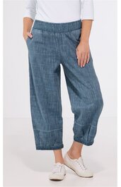 Hose aus blauem Denim mit elastischem Bund, Taschen seitlich, weite Beine, umgeschlagene Säume, getragen von stehendem Modell, knöchellang