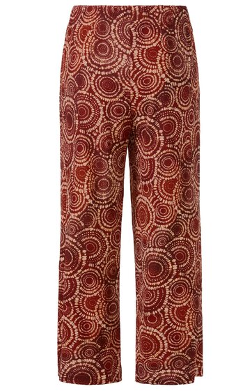 Weite Hose in Rostrot mit braunem und hellbeigem kreisförmigem Muster, gerader Schnitt, elastischer Bund, fußfrei, seitliche Schlitze am Saum