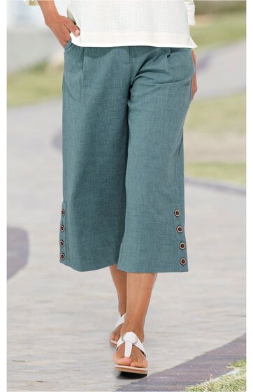 Damenhose, türkisgrün, knielang, weites Bein, seitliche Eingrifftaschen, Knopfdetails am Saum, getragen von Person im Stehen