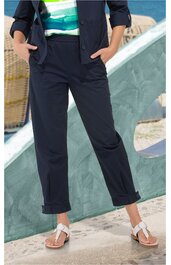 Dunkelblaue Hose mit geradem Bein, aufgekrempeltem Saum, seitlichen Eingrifftaschen, getragen von stehendem Modell, kombiniert mit weißem Sandalenpaar