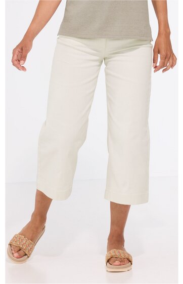 Weiß-beige Damenhose, locker sitzend, 7/8-Länge, gerade geschnitten, ohne sichtbare Muster, getragen von stehender Frau, kombiniert mit hellgrauem Oberteil und beigen Sandalen