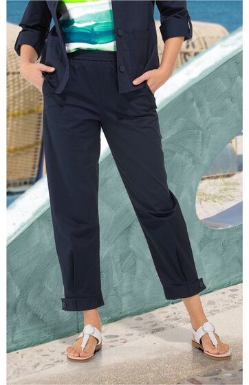 Dunkelblaue Hose mit geradem Bein, aufgekrempeltem Saum, seitlichen Eingrifftaschen, getragen von stehendem Modell, kombiniert mit weißem Sandalenpaar
