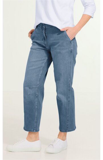 Hose in mittlerem Blauton, gerade geschnitten, mit Hosentaschen, Bund mit Gürtelschlaufen, getragen von stehender Person mit Händen in den Taschen, kombiniert mit weißem Oberteil und weißen Sneakern