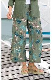 Weite, knöchellange Hose in Olivgrün mit blau-cremefarbenem Blättermuster, elastischer Bund mit Kordel, getragen von stehender Person