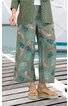Weite, knöchellange Hose in Olivgrün mit blau-cremefarbenem Blättermuster, elastischer Bund mit Kordel, getragen von stehender Person