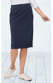 Dunkelblauer knielanger Rock, gerade geschnitten, leichter Schlitz vorne, getragen von stehender Person, kombiniert mit weißen Schuhen