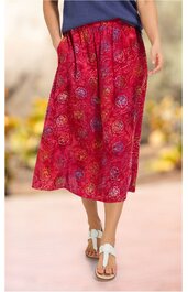 Roter Midirock mit mehrfarbigem Blumenmuster, elastischer Bund, weite Form, getragen von stehender Person, casual Look