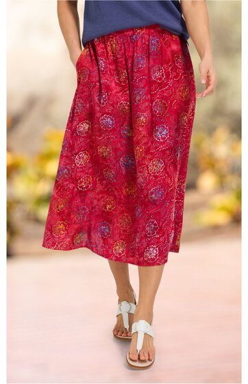 Roter Midirock mit mehrfarbigem Blumenmuster, elastischer Bund, weite Form, getragen von stehender Person, casual Look