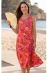 Ärmelloses, knielanges Sommerkleid in Rot- und Orangetönen mit floralem Muster, V-Ausschnitt, gerade geschnitten, getragen von stehendem Modell am Strand, locker fließender Stoff
