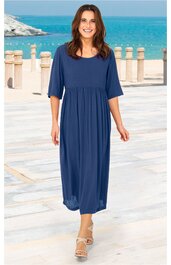 Marineblaues, knielanges Kleid ohne Muster, rundhalsausschnitt, dreiviertellange Ärmel, ausgestellte Form unterhalb der Brust, getragen von stehender Frau in Sandalen