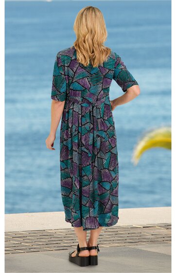 Midikleid in dunklem Türkis mit geometrischem Muster in Dunkelblau und Violett, halblange Ärmel, Taillennaht, Rundhalsausschnitt hinten mit Schlitz, getragen von stehender Frau mit Rücken zum Betrachter, lässiger Schnitt
