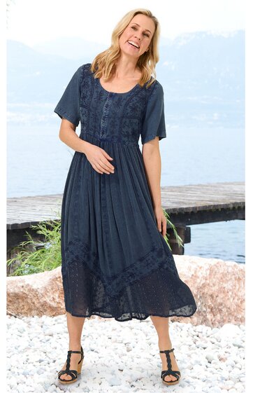 Dunkelblaues Midikleid mit kurzem Ärmel, florales Spitzenmuster am Oberteil und Saum, Rundhalsausschnitt, ausgestellter Rock, getragen von stehender lächelnder Frau, luftige Passform