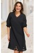 Schwarzes Kleid ohne Muster, V-Ausschnitt, lange Ärmel mit aufgekrempelten Bündchen, knielang, leicht ausgestellte Form, getragen von lachender stehender Frau