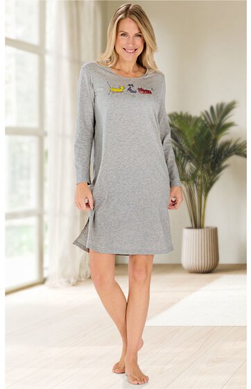 Hellgraues Nachthemd mit buntem Schriftzug auf der Brust, Rundhalsausschnitt, lange Ärmel, knielanger Schnitt mit seitlichen Schlitzen, getragen von stehender Frau mit lächelndem Gesichtsausdruck