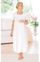 Weißes langes Nachthemd, kurzärmlig, quadratischer Ausschnitt mit Rüschendetail, gerade geschnitten, getragen von stehender Person, knöchellang