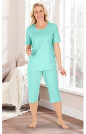Mintgrünes Hausanzug-Set bestehend aus locker sitzendem T-Shirt mit rundem Ausschnitt und Capri-Hose, getragen von stehender Frau, kurze Ärmel, hüftlang