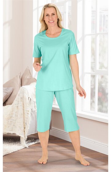 Mintgrünes Hausanzug-Set bestehend aus locker sitzendem T-Shirt mit rundem Ausschnitt und Capri-Hose, getragen von stehender Frau, kurze Ärmel, hüftlang