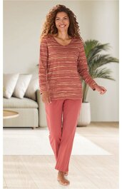 Langärmliges Pullover-Shirt in rostrot mit hellbeigen, horizontalen Streifen, V-Ausschnitt, locker sitzend, getragen von lächelnder stehender Frau, Unterteil in ziegelrot