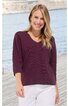 Damenpullover in dunklem Lila, einfarbig, Rundhalsausschnitt, lange Ärmel, gerade geschnitten, getragen von stehender Frau vor Wasser und Holzsteg