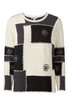 Langärmliger Pullover in Cremeweiß und Schwarz, patchworkartiges Muster mit groben Nähten, runder Ausschnitt, schwarze florale Stickereien auf Vorderteil und Ärmeln