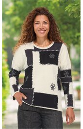 Pullover mit langem Arm, cremeweiß und schwarz im Muster aus rechteckigen Feldern, mit Blumenmuster und Ziernähten, Rundhalsausschnitt, getragen von lächelnder stehender Frau, lockere Passform