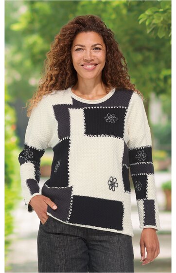 Pullover mit langem Arm, cremeweiß und schwarz im Muster aus rechteckigen Feldern, mit Blumenmuster und Ziernähten, Rundhalsausschnitt, getragen von lächelnder stehender Frau, lockere Passform