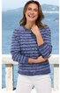 Gestreifter Pullover in Blautönen, Rundhalsausschnitt, lange Ärmel, getragen von lächelnder Frau stehend, weißer Rock, Hintergrund Meer und Felsküste