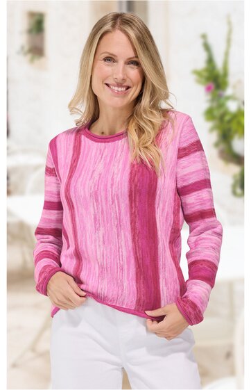 Langärmliger Pullover in verschiedenen Rosatönen, gestreiftes Muster, rundhalsausschnitt, gerade geschnitten, getragen von lächelnder, stehender Frau mit hellblonden Haaren, locker sitzend