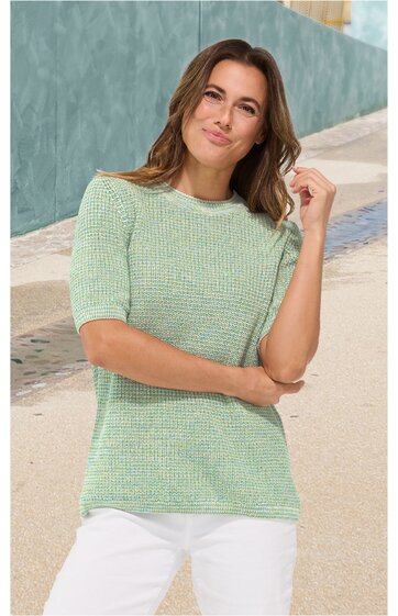 Kurzärmliges Strickoberteil in Hellgrün mit feinem Rautenmuster, gerader Rundhalsausschnitt, getragen von stehender Frau, lockere Passform
