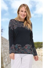 Dunkelblauer Pullover mit Paisley-Muster in Rot- und Blautönen, Rundhalsausschnitt, lange Ärmel, gerade geschnitten, getragen von lächelnder stehender Frau mit blonden Haaren, kombiniert mit weißen Hosen