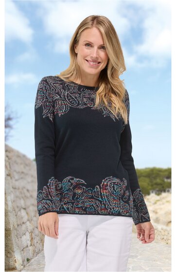 Dunkelblauer Pullover mit Paisley-Muster in Rot- und Blautönen, Rundhalsausschnitt, lange Ärmel, gerade geschnitten, getragen von lächelnder stehender Frau mit blonden Haaren, kombiniert mit weißen Hosen