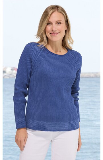 Blauer Rundhalspullover mit Strukturmuster, lange Raglanärmel, gerader Schnitt, getragen von stehender Frau vor Meereshintergrund