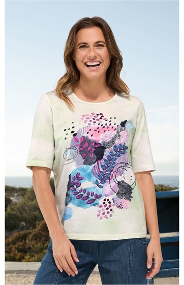 Kurzärmeliges T-Shirt in cremeweiß mit mehrfarbigem abstraktem Blumenmuster in Rosa, Blau, Lila und Schwarz, Rundhalsausschnitt, gerade geschnitten, getragen von lächelnder stehender Frau