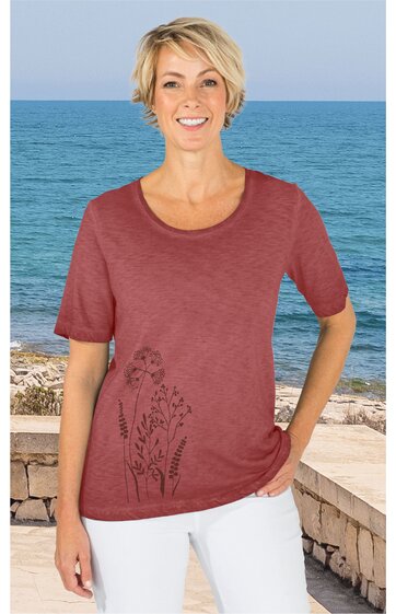 Rotes Kurzarmshirt mit floralem Druck auf der Vorderseite, Rundhalsausschnitt, gerade geschnitten, getragen von stehender Frau vor Meereskulisse