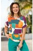 Kurzärmliges Damenoberteil mit rundem Ausschnitt, buntes geometrisches Muster in Orange, Türkis, Lila und Weiß, Ärmel mit Knoten, getragen von lachender Frau in stehender Pose