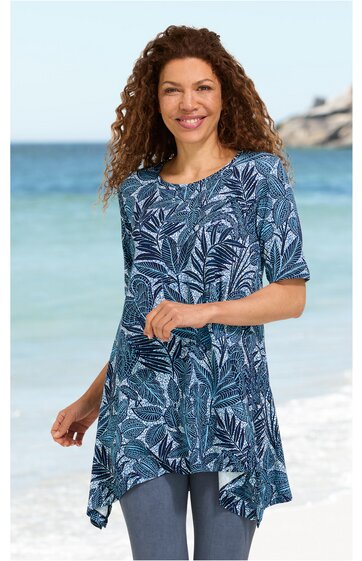 Langes Rundhalsshirt, dunkelblau mit weißem Blattmuster, asymmetrischer Saum, halblange Ärmel, getragen von lächelnder Frau am Strand, locker sitzend