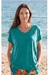 Türkisfarbenes T-Shirt mit V-Ausschnitt und kurzen Ärmeln, locker sitzend, getragen von frontal stehender Frau am Strand
