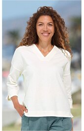 Weißes Damenoberteil mit V-Ausschnitt, 3/4-Ärmeln, kastiger Form, getragen von lächelnder Frau mit lockigen Haaren in stehender Pose