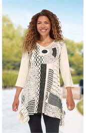 Beige Tunika mit schwarzen und weißen abstrakten Mustern, U-Boot-Ausschnitt, dreiviertellange Ärmel, asymmetrischer Saum, getragen von lachender stehender Frau