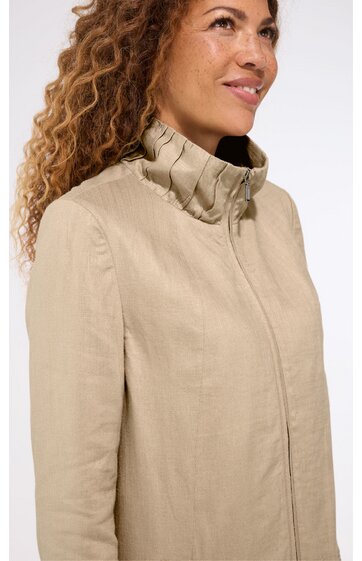 Beige Mantel ohne Muster, Stehkragen mit Rüschen, verdeckter Reißverschluss, gerade geschnitten, getragen von seitlich stehender Person