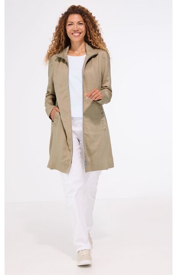 Beiger langärmliger Mantel ohne Muster, mit Umlegekragen, verdeckter Knopfleiste, aufgesetzten Taschen, knielang, getragen von stehender Frau mit weißen Schuhen und weißer Hose