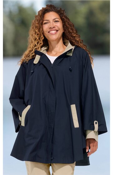 Dunkelblaue Kapuzenjacke mit beigen Details an Kragen, Ärmelbündchen und Taschen, durchgehender Reißverschluss mit verdeckter Blende, lockere Passform, getragen von lächelnder stehender Frau