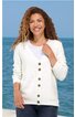 Weißer Damenstrickcardigan mit V-Ausschnitt und sechs braunen Knöpfen, langärmlig, gerade geschnitten, getragen von lächelnder Frau vor Meereskulisse