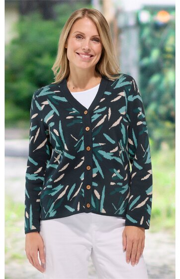 Dunkelblauer Cardigan mit abstraktem Muster in Grün und Beige, V-Ausschnitt, durchgehende Knopfleiste mit braunen Knöpfen, langärmlig, getragen von lächelnder Frau in stehender Position